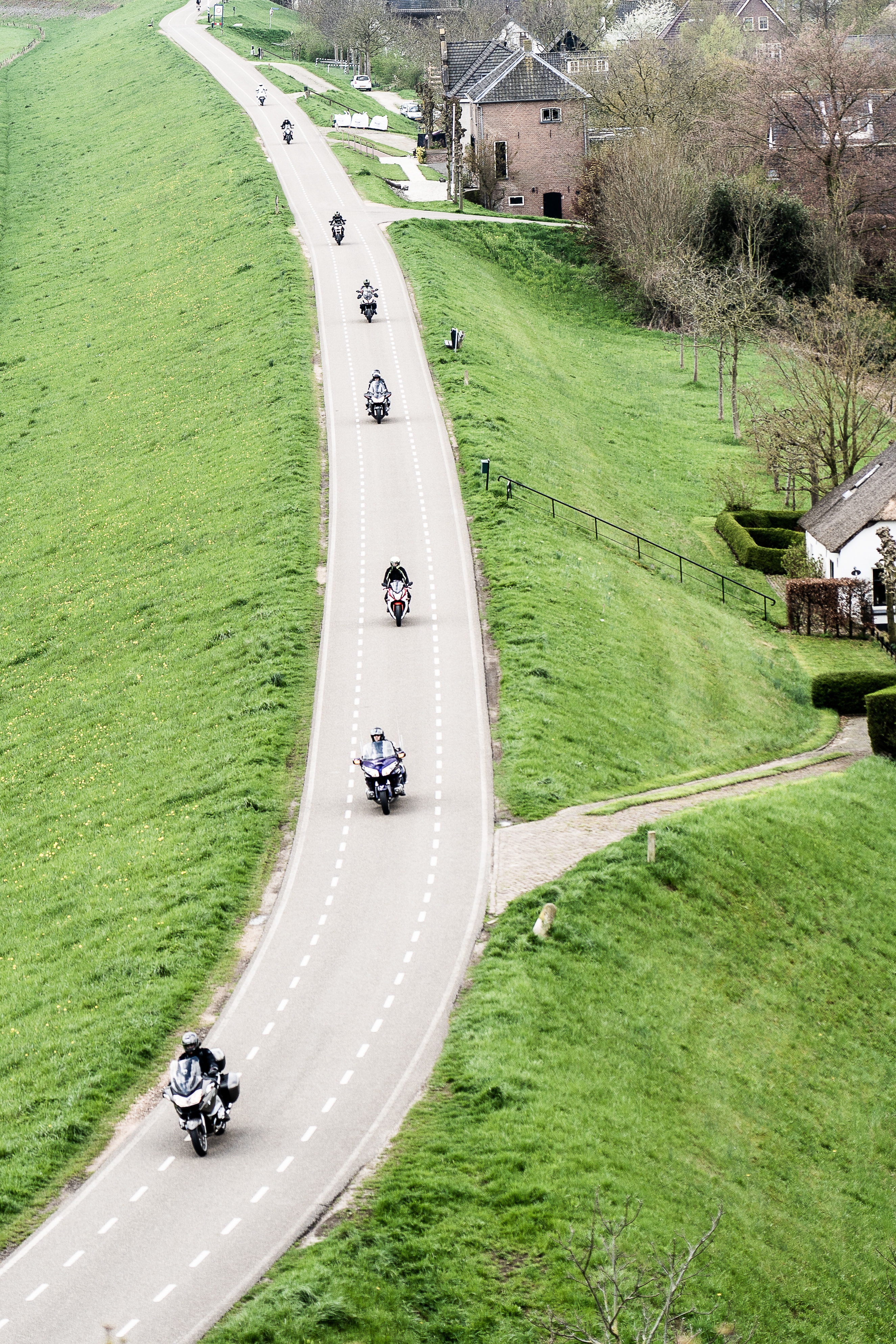 Grupo de motos sobre camino entre campos verdes